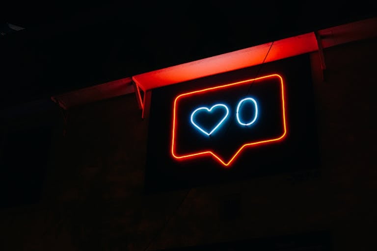 Bright neon heart icon with zero likes, symbolizing social media engagement.